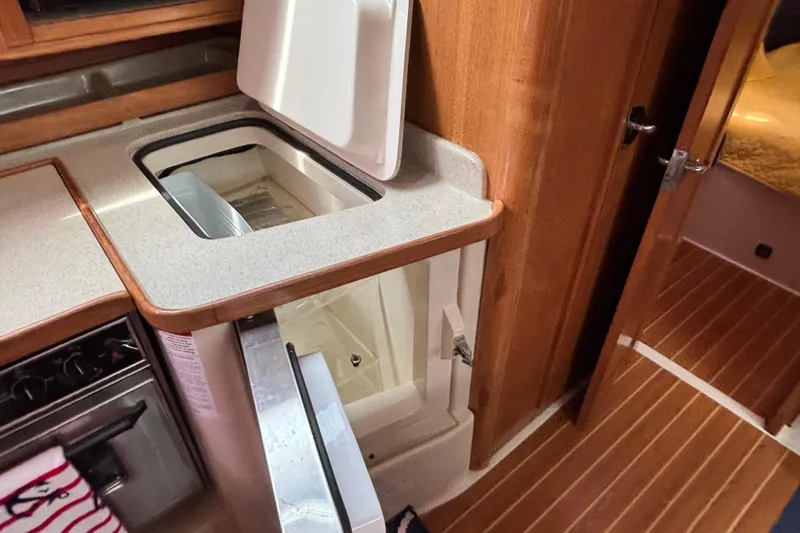  Yacht Photos Pics 2006 Catalina 42 MkII yacht interior with open fridge and wooden cabinetry.