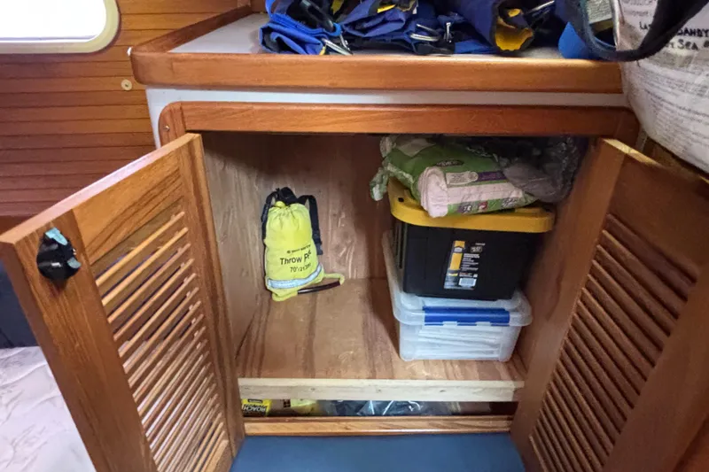  Yacht Photos Pics Open wooden cabinet on a 2006 Catalina 42 MkII sailboat, storing gear and supplies.