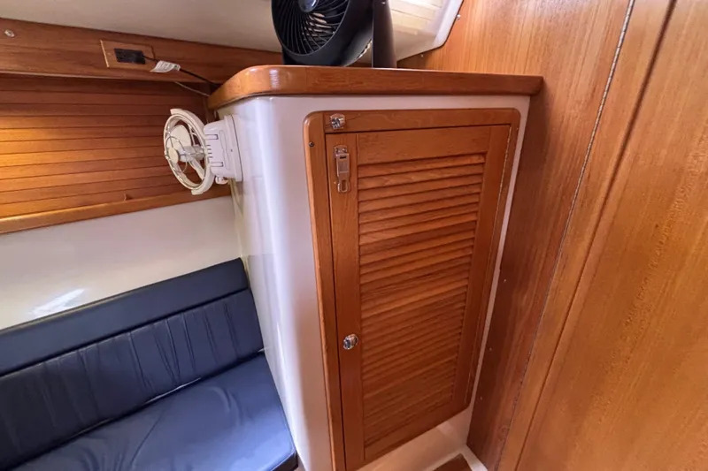  Yacht Photos Pics Wooden interior of a 2006 Catalina 42 MkII sailboat with a fan and seating.
