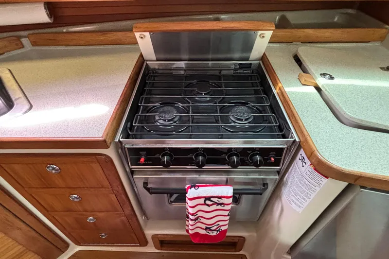  Yacht Photos Pics Galley kitchen in 2006 Catalina 42 MkII sailboat with stove and wooden cabinetry.