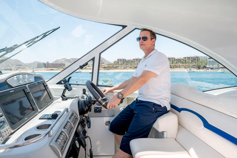 Baja 22 With Dry Storage In Cabo San Lucas Yacht Photos Pics Man piloting 2007 Formula 45 Yacht on sunny day, coastal view in background.