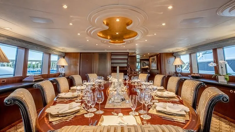 Never Enough Yacht Photos Pics Luxurious dining area on a 1992 Feadship 140 Tri-Deck yacht, elegantly set table.