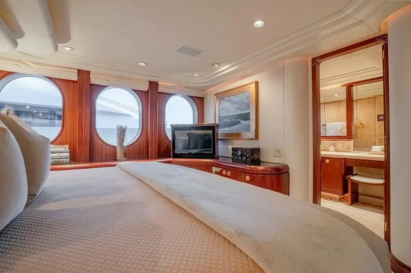 Never Enough Yacht Photos Pics Luxurious bedroom on a 1992 Feadship 140 Tri-Deck yacht with porthole windows and en-suite bathroom.