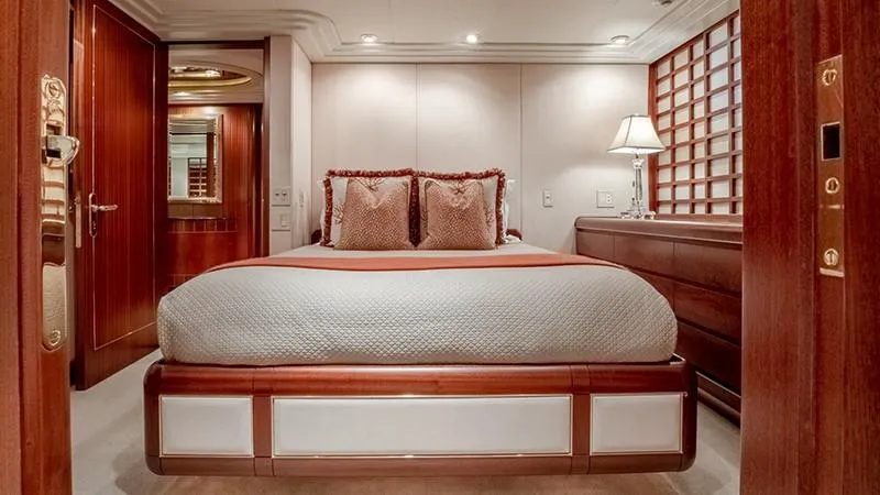Never Enough Yacht Photos Pics Luxurious bedroom on a 1992 Feadship 140 Tri-Deck yacht with elegant wood finishes.