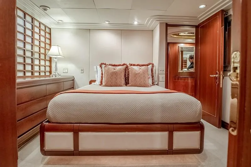 Never Enough Yacht Photos Pics Luxurious bedroom on a 1992 Feadship 140 Tri-Deck yacht with elegant decor.