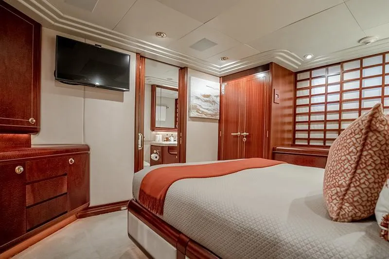 Never Enough Yacht Photos Pics Luxurious bedroom on a 1992 Feadship 140 Tri-Deck yacht with modern amenities.