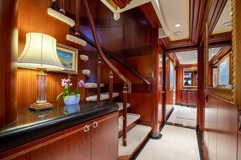 Never Enough Yacht Photos Pics Luxurious interior of 1992 Feadship 140 Tri-Deck yacht with elegant staircase and wooden finishes.