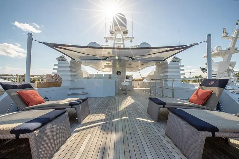 Never Enough Yacht Photos Pics Luxurious deck of 1992 Feadship 140 Tri-Deck yacht with sun loungers and canopy.