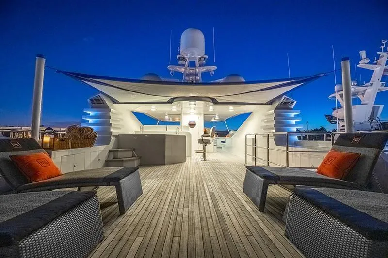 Never Enough Yacht Photos Pics Luxurious deck of 1992 Feadship 140 Tri-Deck yacht at sunset.