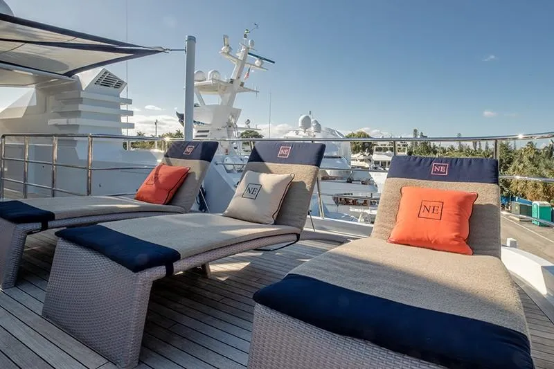 Never Enough Yacht Photos Pics Luxury sun loungers on Feadship 140 Tri-Deck yacht, 1992 model, with scenic marina view.