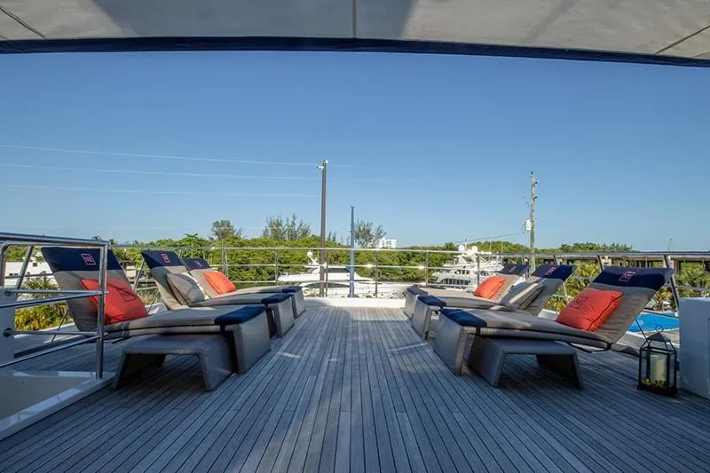 Never Enough Yacht Photos Pics Sun deck of 1992 Feadship 140 Tri-Deck yacht with lounge chairs and scenic view.