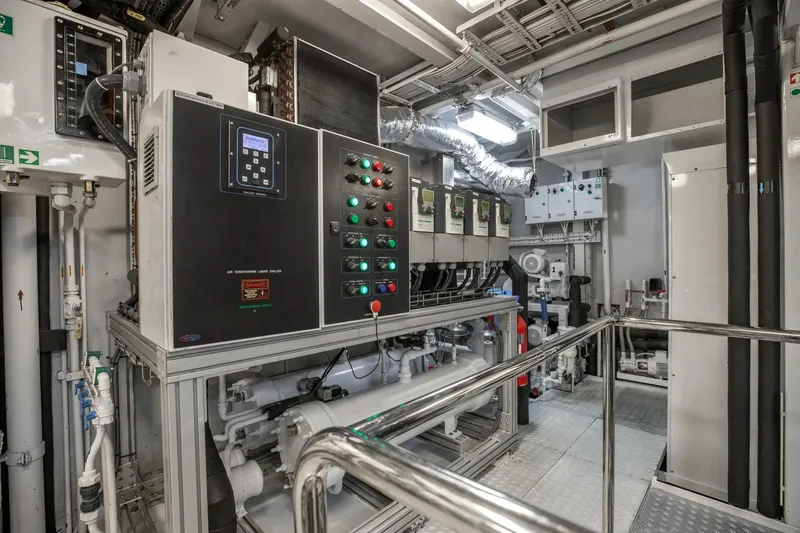 Never Enough Yacht Photos Pics Engine room of a 1992 Feadship 140 Tri-Deck yacht with control panels and machinery.