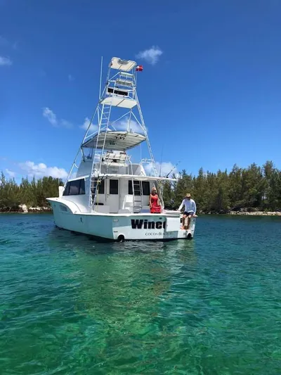 Wined Up Yacht Photos Pics 1973 Hatteras 53 yacht on clear water with two people aboard, surrounded by trees.