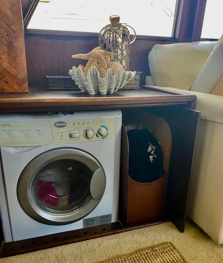 Wined Up Yacht Photos Pics Compact laundry area on a 1973 Hatteras 53 yacht with decorative starfish and shell.