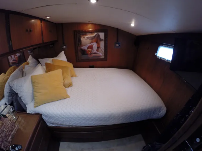 Wined Up Yacht Photos Pics Cozy bedroom interior of a 1973 Hatteras 53 yacht with elegant decor and soft lighting.