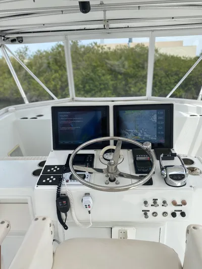Wined Up Yacht Photos Pics Helm of 1973 Hatteras 53 yacht with dual navigation screens and steering wheel.