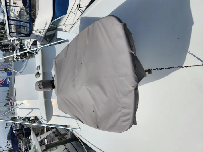 Wined Up Yacht Photos Pics 1973 Hatteras 53 yacht deck with covered equipment, docked in a marina.