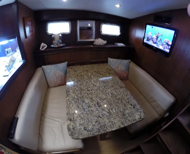Wined Up Yacht Photos Pics Interior of 1973 Hatteras 53 yacht with granite table and cozy seating area.
