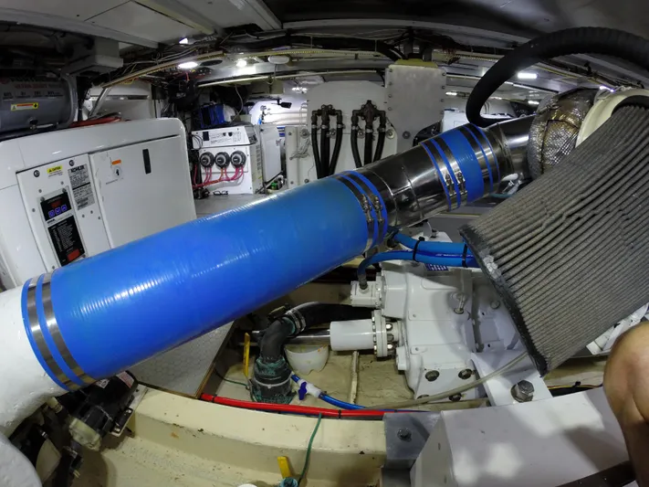 Wined Up Yacht Photos Pics Engine room of a 1973 Hatteras 53 yacht with visible machinery and blue piping.