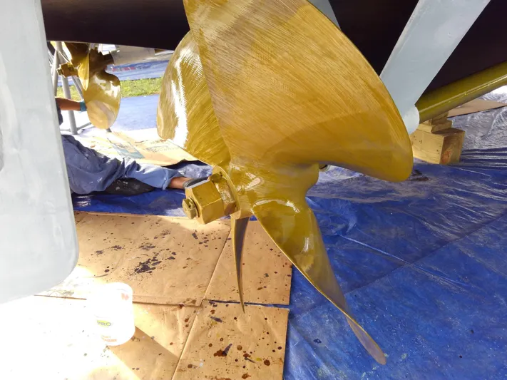 Wined Up Yacht Photos Pics 1973 Hatteras 53 boat propeller undergoing maintenance on a tarp-covered surface.