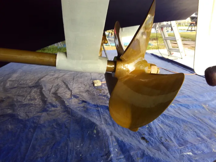 Wined Up Yacht Photos Pics Polished propeller of a 1973 Hatteras 53 yacht on a blue tarp.