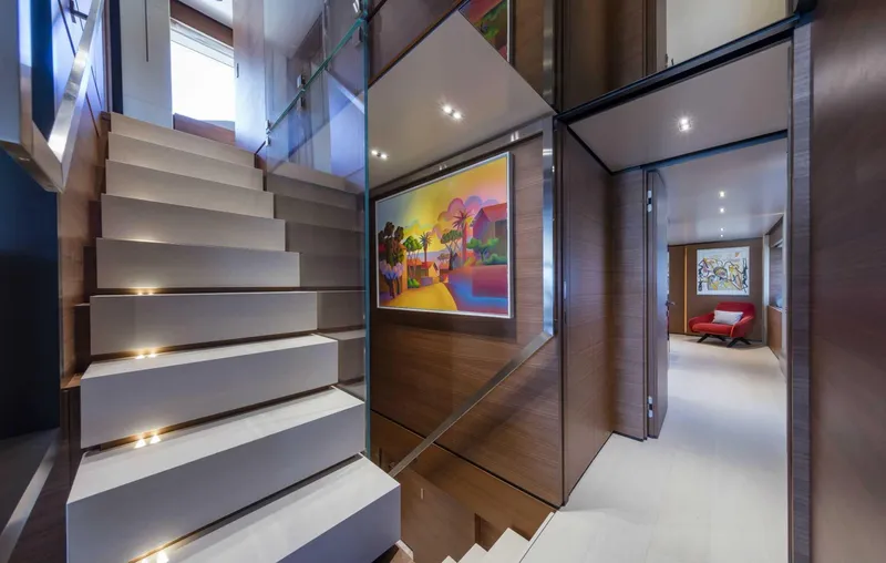 Yacht Photos Pics Luxurious interior of 2025 Custom Line Navetta 33 yacht with modern staircase and vibrant artwork.