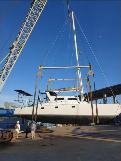 Hiolani II Yacht Photos Pics CSK Polycon 1988 catamaran being lifted by crane at a shipyard.