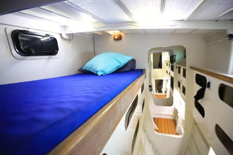 Hiolani II Yacht Photos Pics Cozy cabin interior of 1988 CSK Polycon with blue bedding and wooden accents.