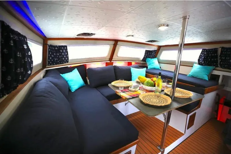 Hiolani II Yacht Photos Pics Cozy 1988 CSK Polycon boat interior with cushioned seating and dining area.