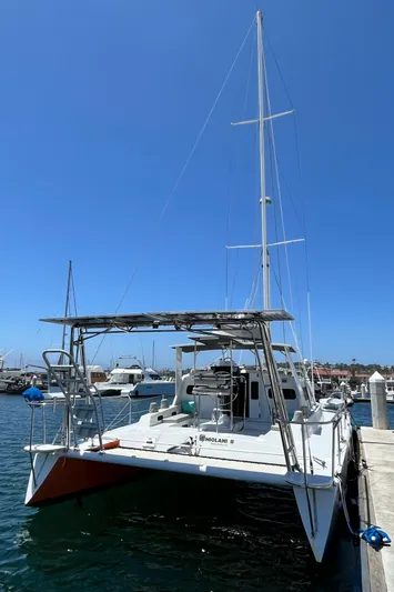 Hiolani II Yacht Photos Pics 1988 CSK Polycon catamaran docked at marina under clear blue sky.
