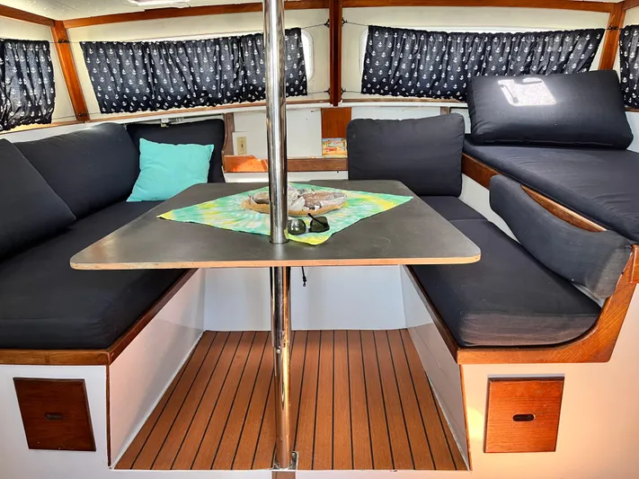 Hiolani II Yacht Photos Pics 1988 CSK Polycon boat interior with cozy seating, table, and nautical decor.