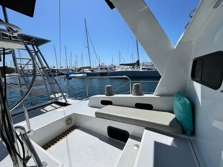 Hiolani II Yacht Photos Pics 1988 CSK Polycon yacht deck with seating, docked at marina under clear blue sky.