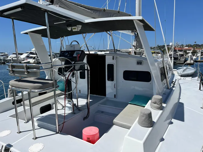 Hiolani II Yacht Photos Pics 1988 CSK Polycon yacht docked at marina, featuring spacious deck and seating area.