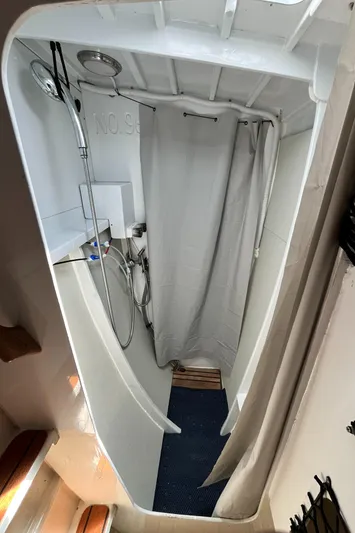 Hiolani II Yacht Photos Pics Compact shower area in a 1988 CSK Polycon boat, featuring a curtain and showerhead.