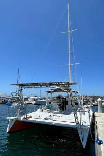 Hiolani II Yacht Photos Pics 1988 CSK Polycon catamaran docked at marina under clear blue sky.