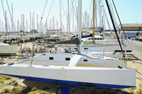 Custom TRIMARAN PULSAR 33 sailboat in a marina, surrounded by other boats, 2002 model.
