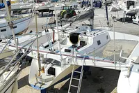 Custom 2002 TRIMARAN PULSAR 33 sailboat in a marina, surrounded by other boats.