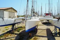 Custom TRIMARAN PULSAR 33 sailboat from 2002 on dry dock, surrounded by other boats.