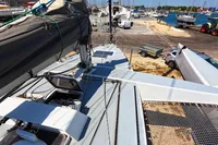 Deck view of 2002 Custom TRIMARAN PULSAR 33 at a marina with boats and vehicles.