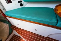 Interior seating of 2002 Custom TRIMARAN PULSAR 33 with teal cushions and wood accents.