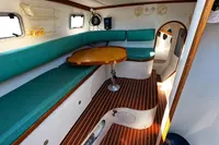 Interior of 2002 Custom TRIMARAN PULSAR 33 with teal seating and wooden table.