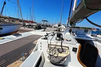 Custom TRIMARAN PULSAR 33 sailboat, 2002 model, docked in a marina under clear blue skies.