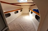 Interior cabin of 2002 Custom TRIMARAN PULSAR 33 with mattress and storage spaces.