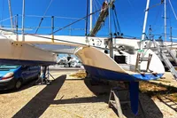 Custom TRIMARAN PULSAR 33 sailboat from 2002 on dry dock, with blue sky background.