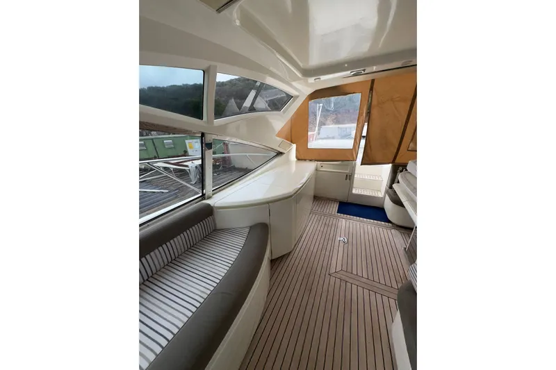  Yacht Photos Pics Interior of 2005 Cantieri di Sarnico 50 yacht with striped seating and wooden flooring.