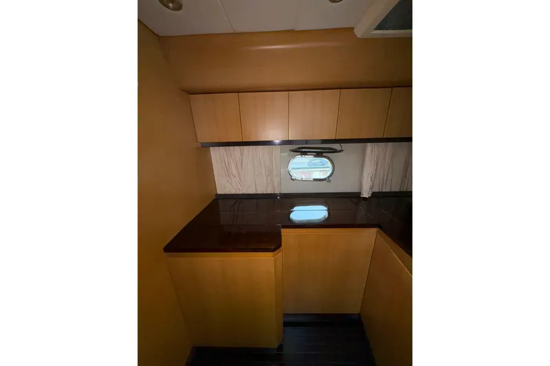  Yacht Photos Pics Interior of 2005 Cantieri di Sarnico 50 yacht, featuring wooden cabinetry and a porthole window.