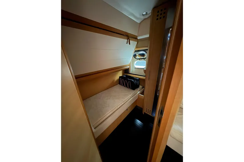  Yacht Photos Pics Interior cabin of 2005 Cantieri di Sarnico 50 yacht, featuring a cozy bed and wooden finishes.