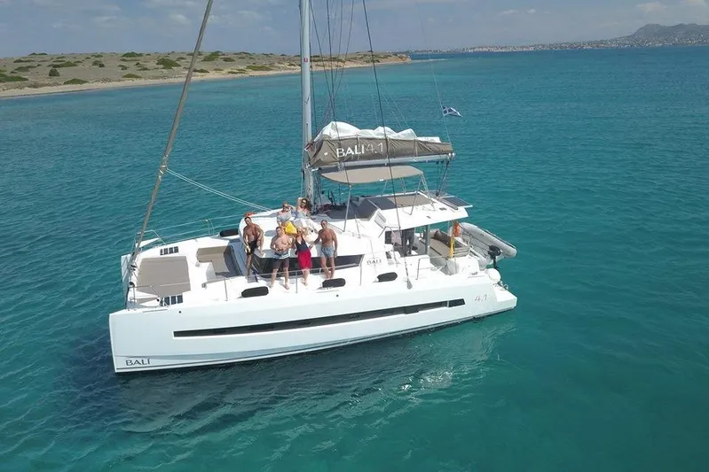 Double Kiss Yacht Photos Pics Aerial view of 2018 Bali 4.1 catamaran with people on deck in turquoise waters.