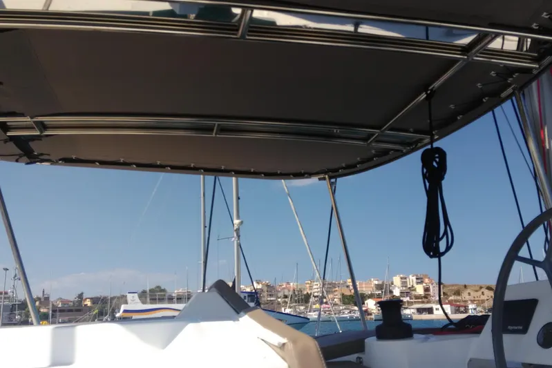 Double Kiss Yacht Photos Pics Bali 4.1 catamaran cockpit view, 2018 model, overlooking marina and coastal buildings.