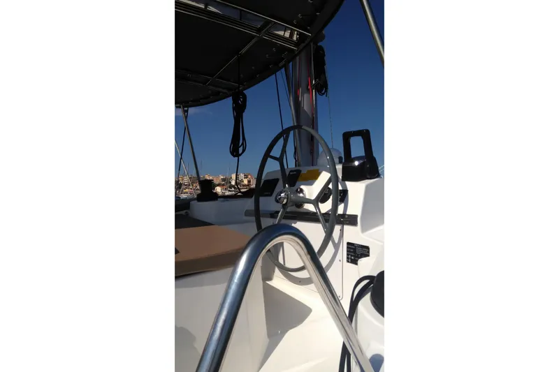 Double Kiss Yacht Photos Pics Steering wheel of a 2018 Bali 4.1 catamaran under clear blue sky.
